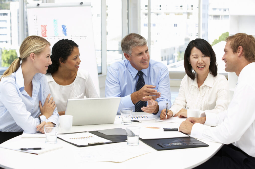 professionals in a meeting sitting and smiling